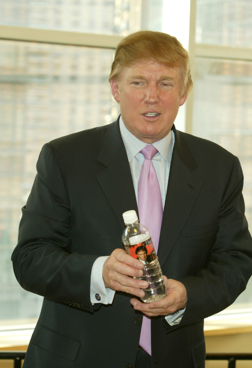 Donald Trump poses with a water bottle that has his picture on it during a book signing in 2004.