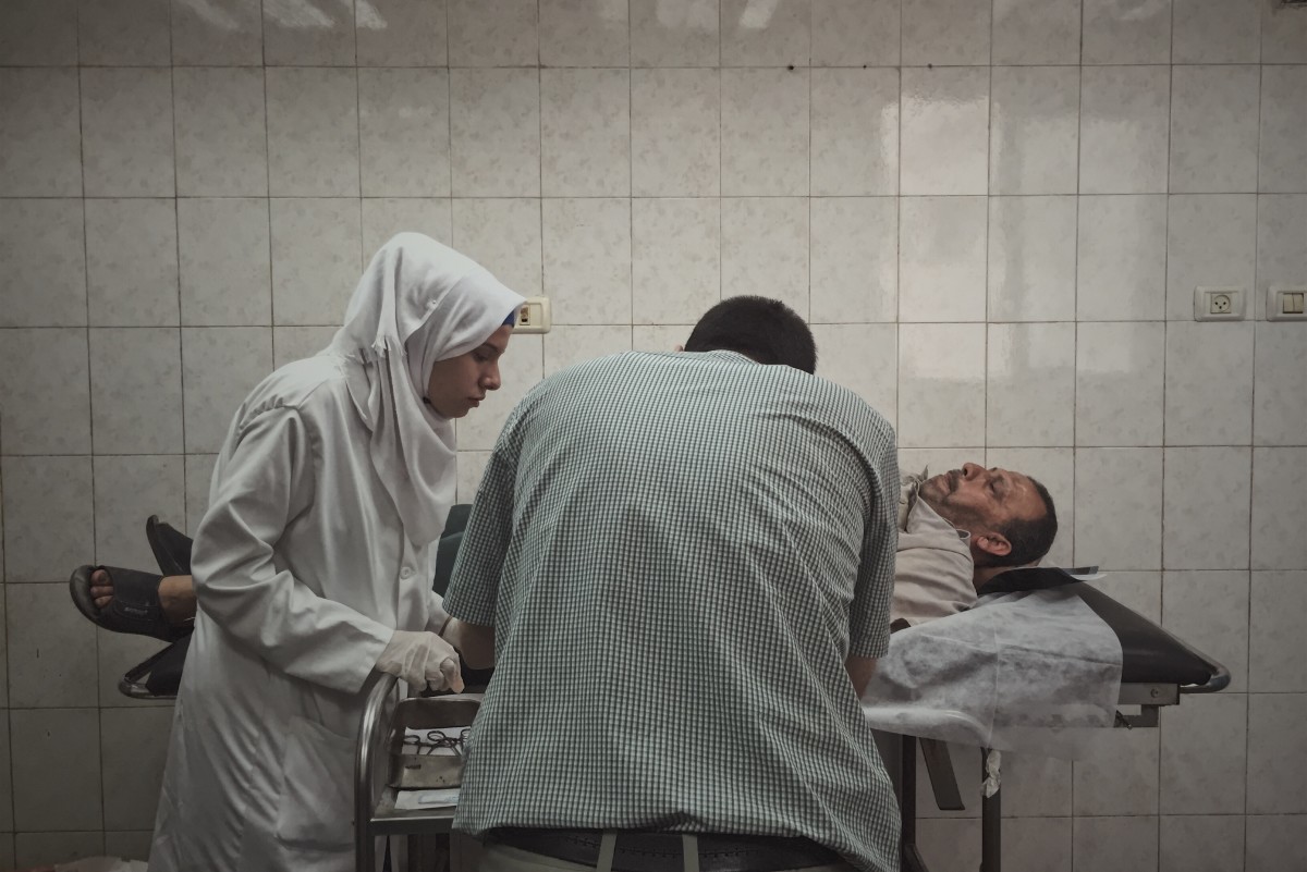 A doctor and nurse stitch a man's finger in Al-Shifa Hospital, one of the largest medical complexes in the Gaza Strip.