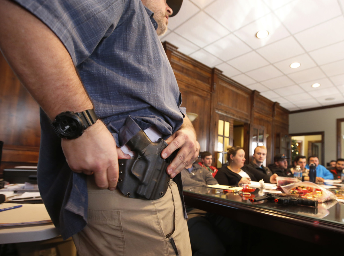 A man shows a holster at a concealed-carry permit class put on by USA Firearms Training on December 19th, 2015, in Provo, Utah.