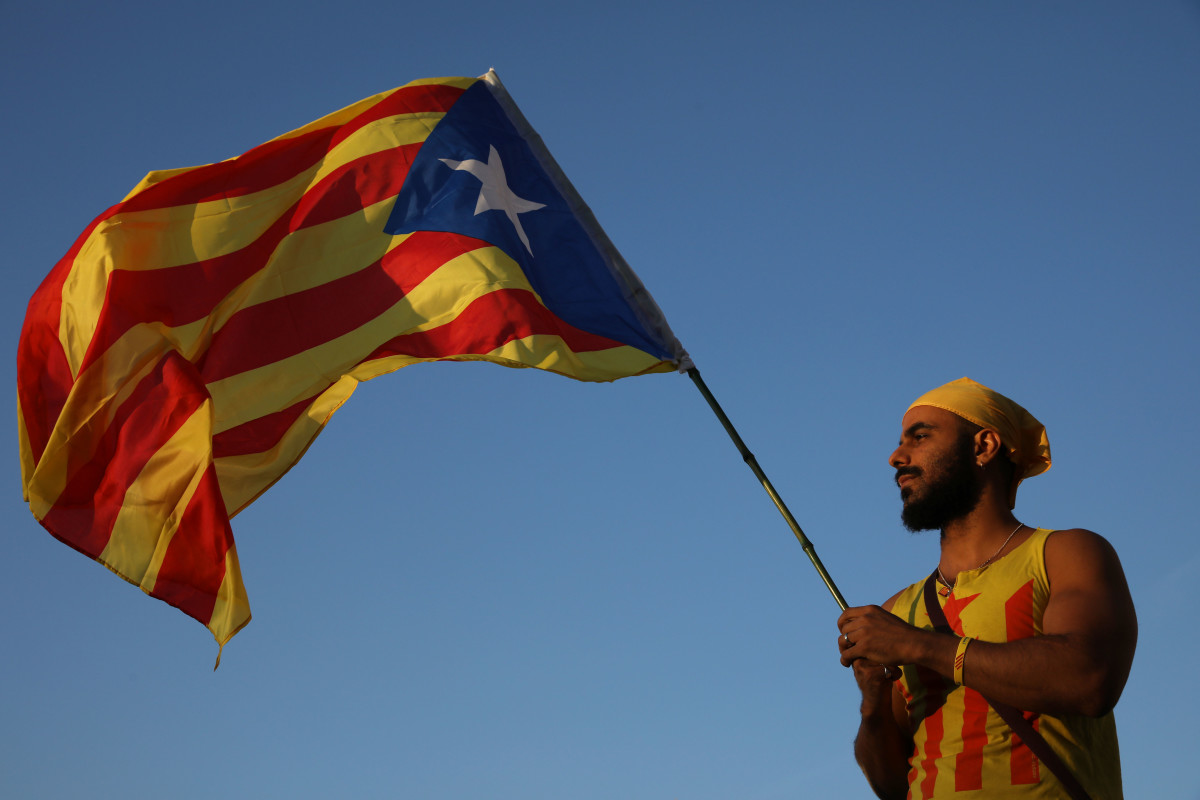 A man holds up a Catalan flag as people gather at the final pro-independence rally at Plaza Espana ahead of Sunday's referendum vote on September 29th, 2017, in Barcelona, Spain.