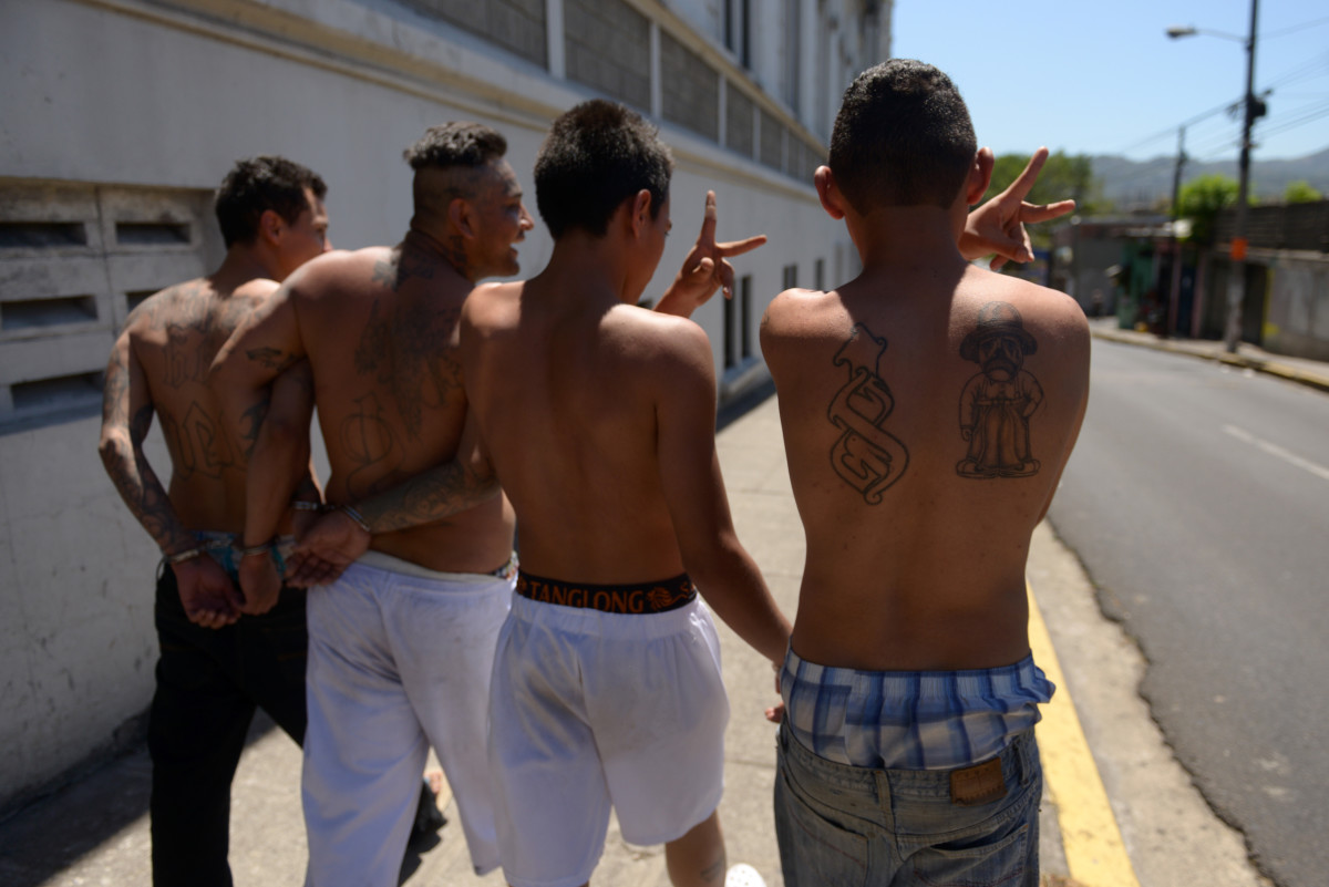 Alleged members of the 18 gang gesture as they walk during their presentation to the press in San Salvador on February 26th, 2016.