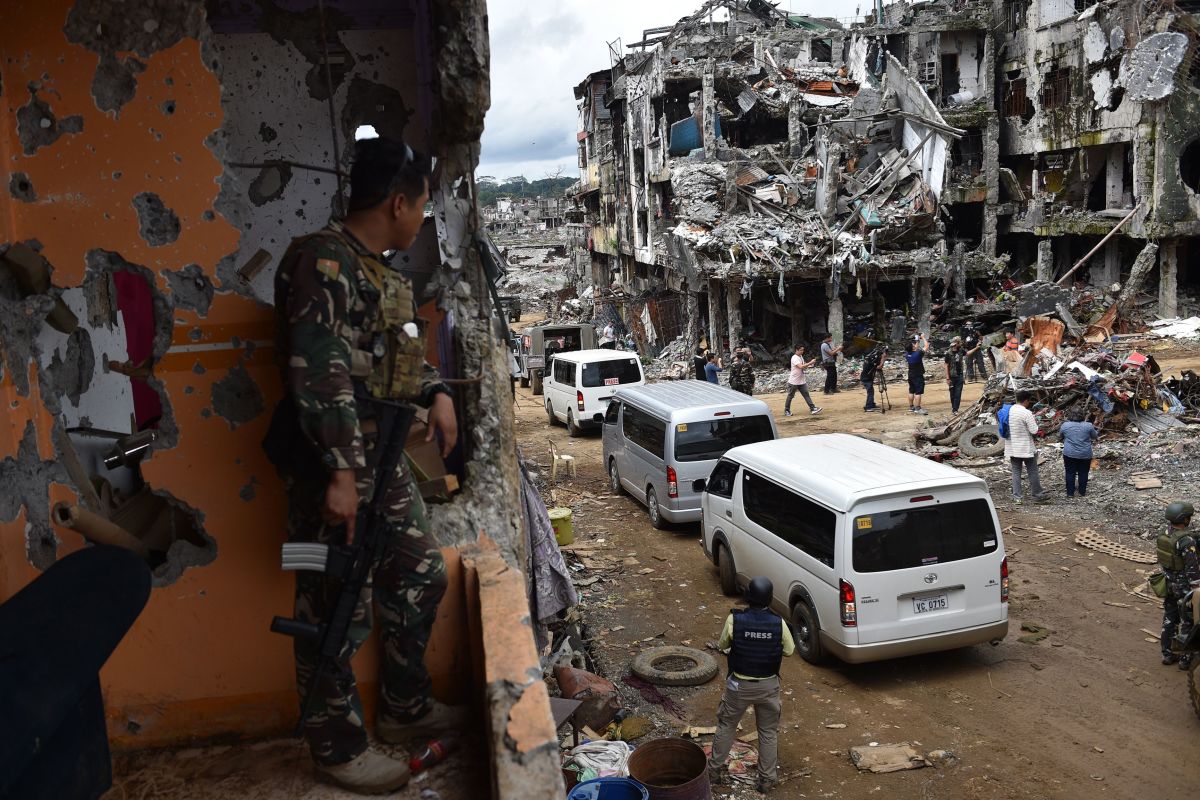 A government soldier watches as journalists tour the ruins of what was the main battle area in Marawi on the southern island of Mindanao on October 25th, 2017, days after the military declared the fighting against IS-inspired Muslim militants over.