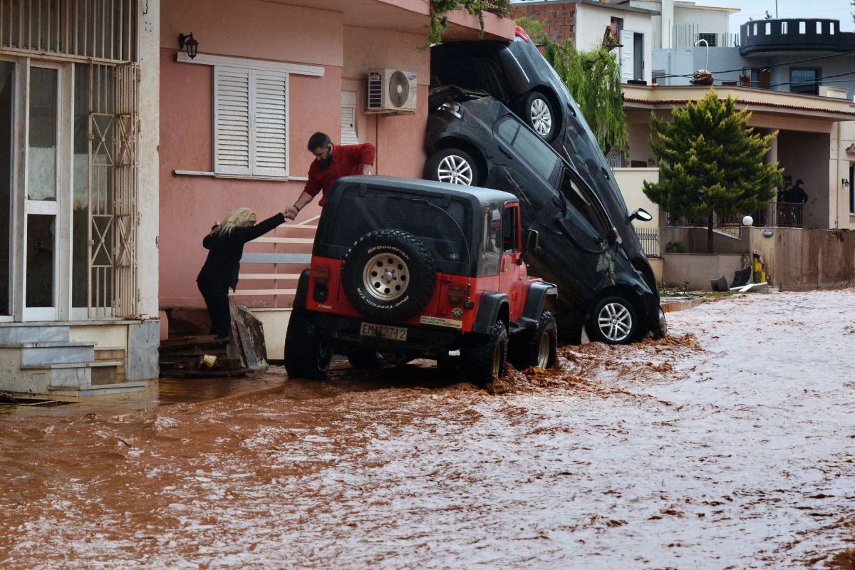 A man helps evacuate a woman from a flooded street in Mandra, Greece, on November 16th, 2017. A sudden overnight downpour flooded three towns near Athens, killing at least 15 people.