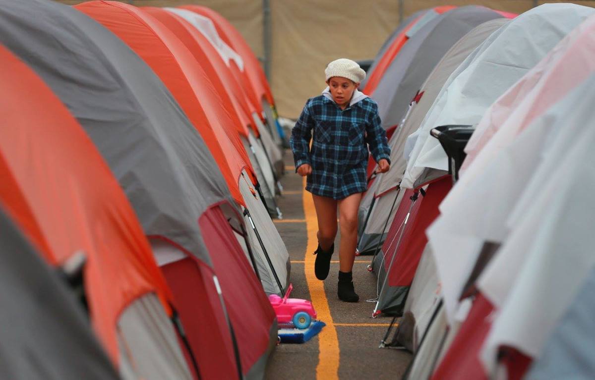 A resident of the Alpha Project campsite walks between tents.