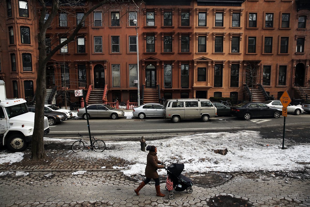 A woman and child walk down a street in the Fort Greene neighborhood where the director and artist Spike Lee once lived on February 27th, 2014, in the Brooklyn borough of New York City.