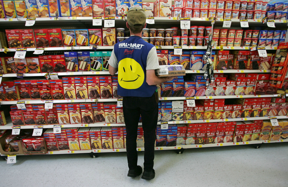 An employee restocks a shelf in the grocery section of a Walmart on May 11th, 2005, in Troy, Ohio.