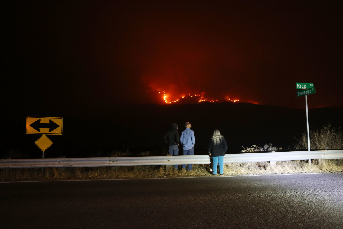 People watch from a roadside as the Thomas Fire burns in the mountains Ojai, California, on December 6th, 2017.