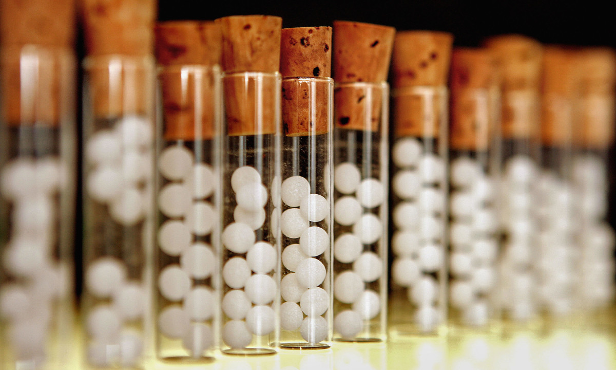 Vials containing pills for homeopathic remedies are displayed at a pharmacy.