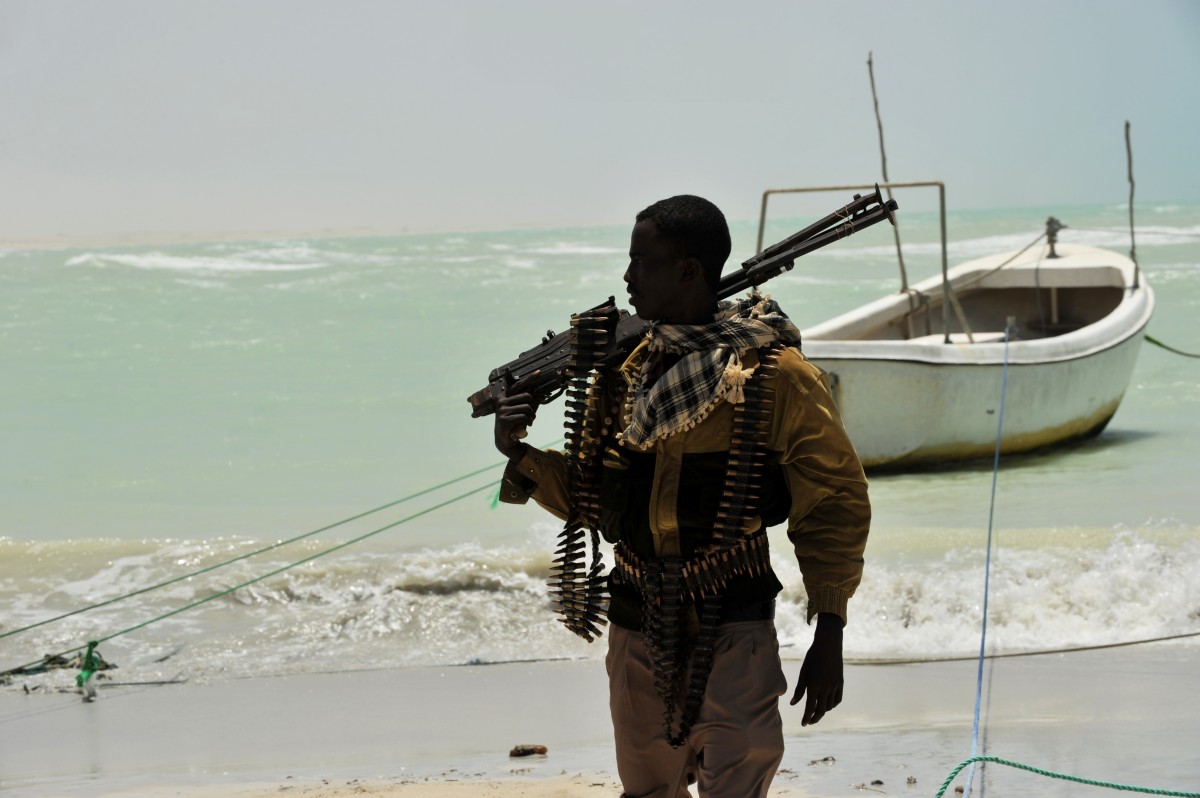 A Somali, part armed militia, part pirate, carries his high-caliber weapon on a beach in the central Somali town of Hobyo on August 20th, 2010.