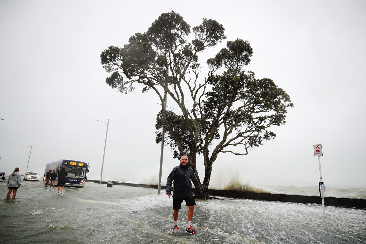 A man walks in the middle of a flooded waterfront on January 5th, 2018, in Auckland, New Zealand. Heavy wind and rain have struck the region, with over 12,000 homes in and around Auckland losing power overnight. More flooding and damage is expected today from continued high winds.