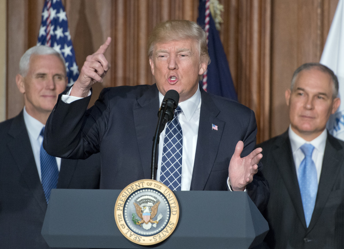 President Donald Trump speaks on March 28th, 2017, in Washington, DC. The order reverses the Obama-era climate change policies. US Vice President Mike Pence look on from left and EPA Administrator Scott Pruitt looks on from the right.