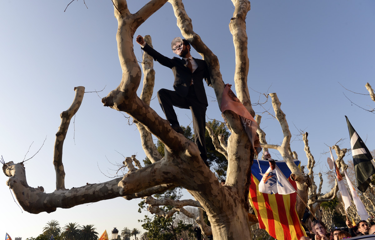 A demonstrator covers his face with a mask depicting ousted separatist leader Carles Puigdemont during a protest outside the Catalan parliament on January 30th, 2018, in Barcelona, Spain. The Parliament delayed a key debate in the regional assembly on Puigdemont's bid to form a new government, but defended his right to return to power.