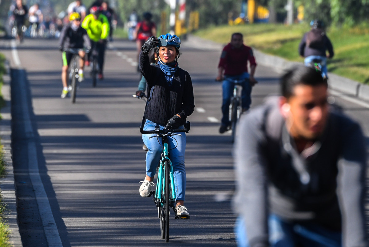 A woman takes a picture while riding her bike during a car-free day in Bogotá, Colombia, on February 1st, 2018. Residents of Bogotá were encouraged to use alternative means of transportation during a car-free day in an attempt to reduce environmental pollution.