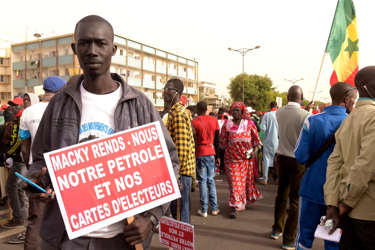 A man carries a placard demanding election rights during a demonstration by opposition parties for free and transparent elections on February 9th, 2018, in Dakar, Senegal. Senegal's presidential elections will be held in 2019.