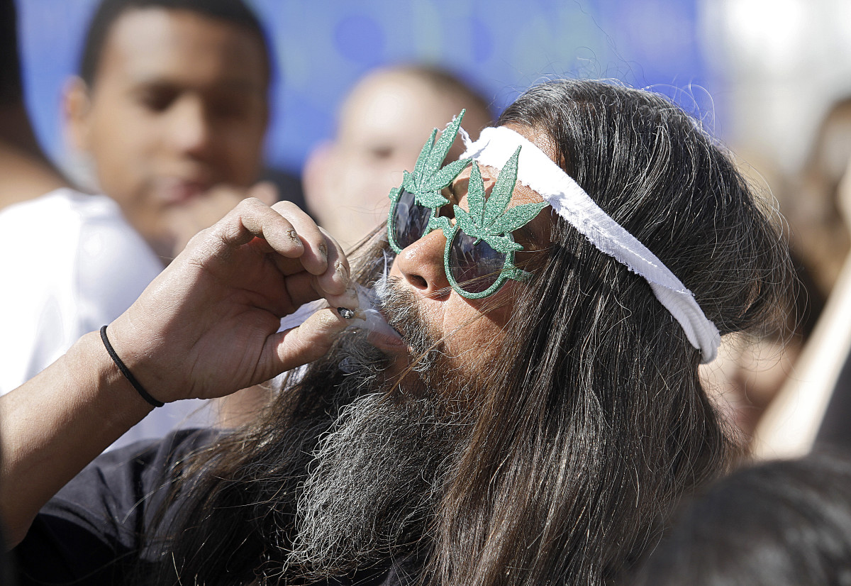 Fast Eddy Aki'a of Hawaii smokes a joint as thousands gathered to celebrate Colorado's medicinal marijuana laws on April 20th, 2012, in Denver, Colorado.