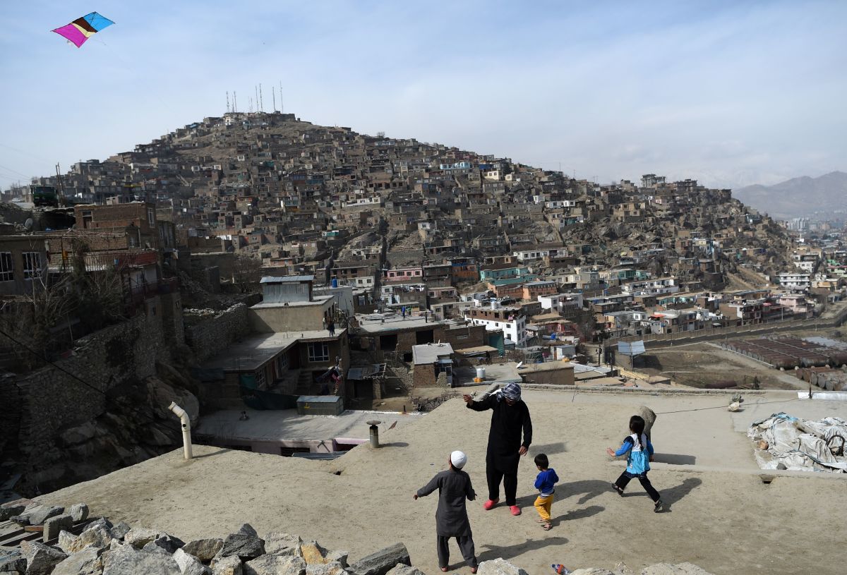 An Afghan man and children play with a kite on a rooftop overlooking Kabul, the capital city of Afghanistan, on February 23rd, 2018.
