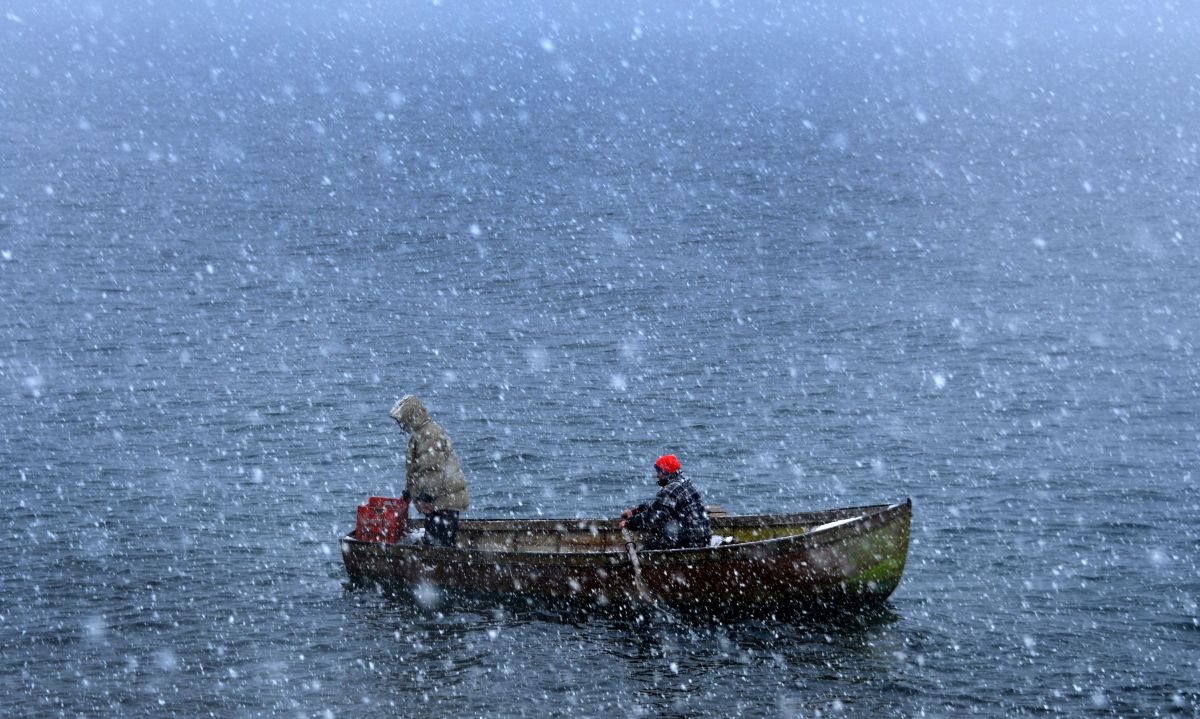 Fishermen row through heavy snowfall as they return to the shores of Lake Ohrid in Pogradec, Albania, on February 27th, 2018. Heavy snow and low temperatures have hit the Balkan countries, including Albania, causing problems for the traffic and power supply.