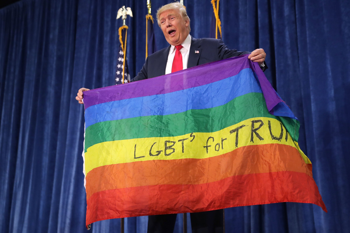 Then-nominee Donald Trump holds an LGBT rainbow flag at a campaign rally in Colorado in October of 2016.