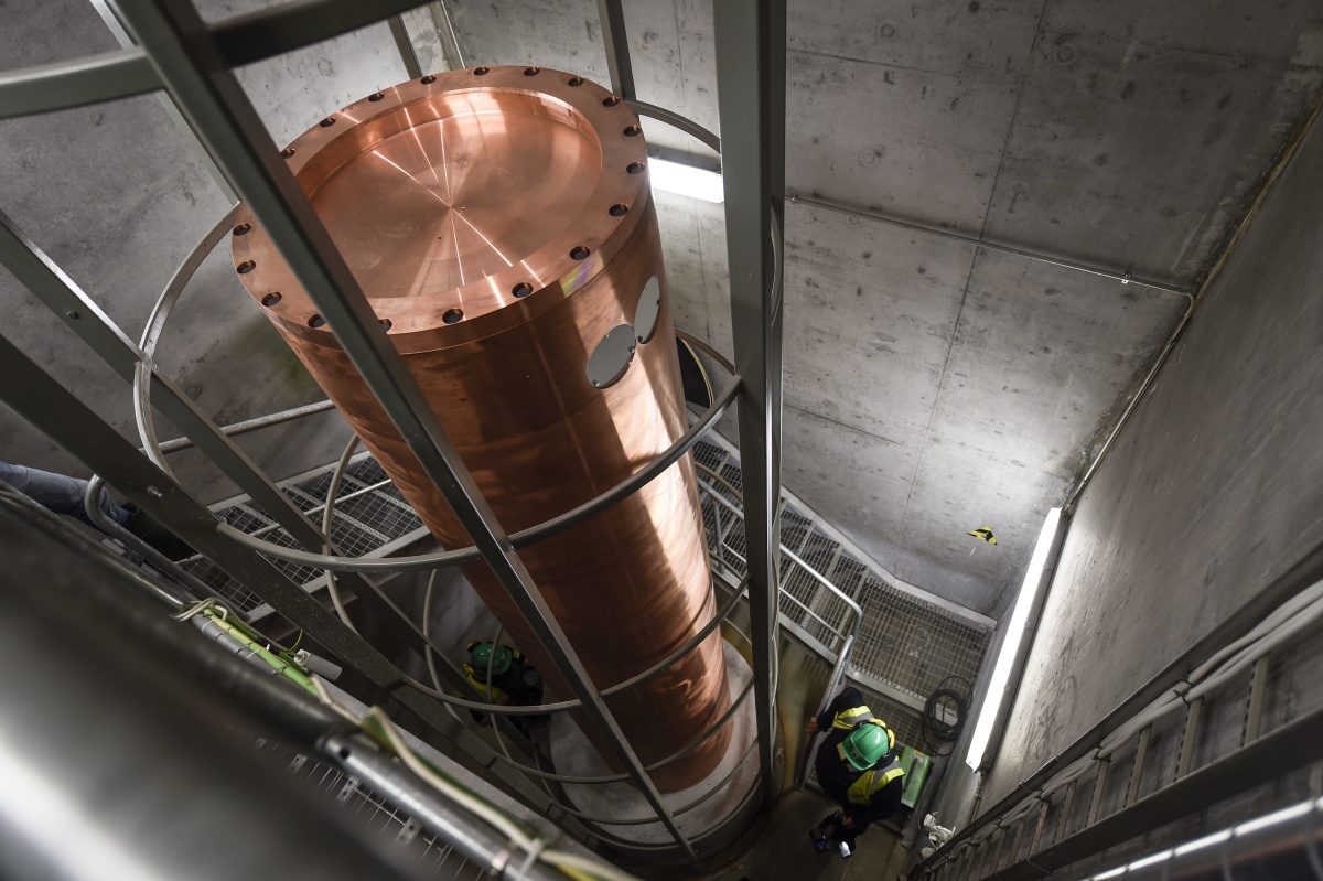 A copper canister for high-level nuclear waste is lowered into one of many storage chambers at Onkalo.