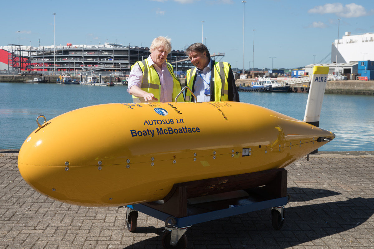 Boris Johnson (L) stands next to Boaty McBoatface, an autonomous underwater vehicle.