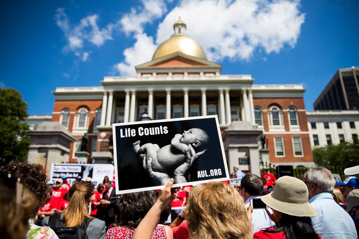 Supporters of Massachusetts Citizens for Life hold signs during a rally outside the Massachusetts Statehouse on June 17th, 2019, in Boston, Massachusetts. Opposing activists were rallying in advance of consideration by lawmakers of measures aimed at loosening restrictions on abortion.