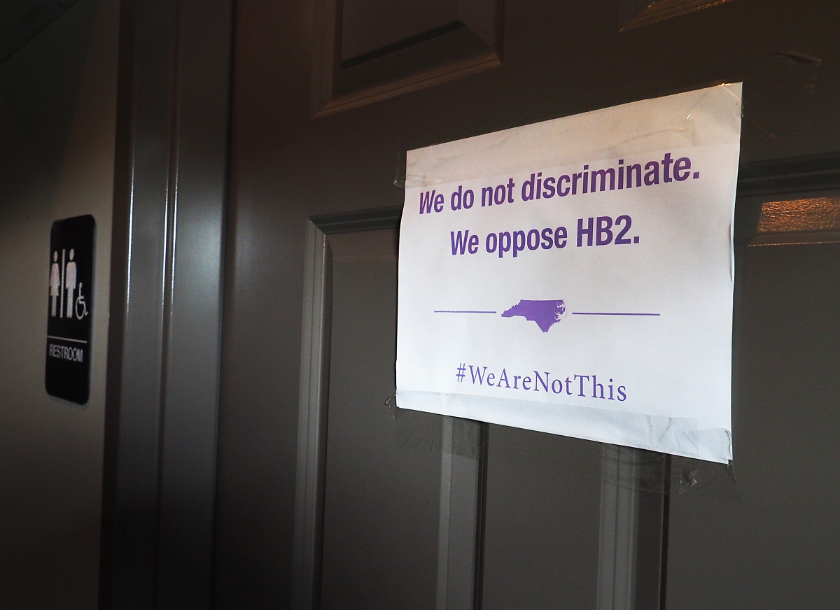 A unisex sign and the "We Are Not This" slogan posted outside a bathroom at a bar, in protest of North Carolina's "bathroom bill," on May 10th, 2016 in Durham, North Carolina.