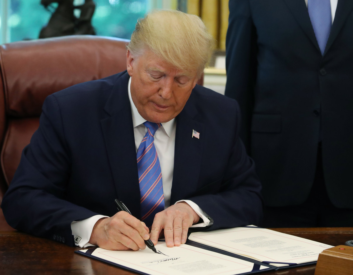 President Donald Trump signs documents.