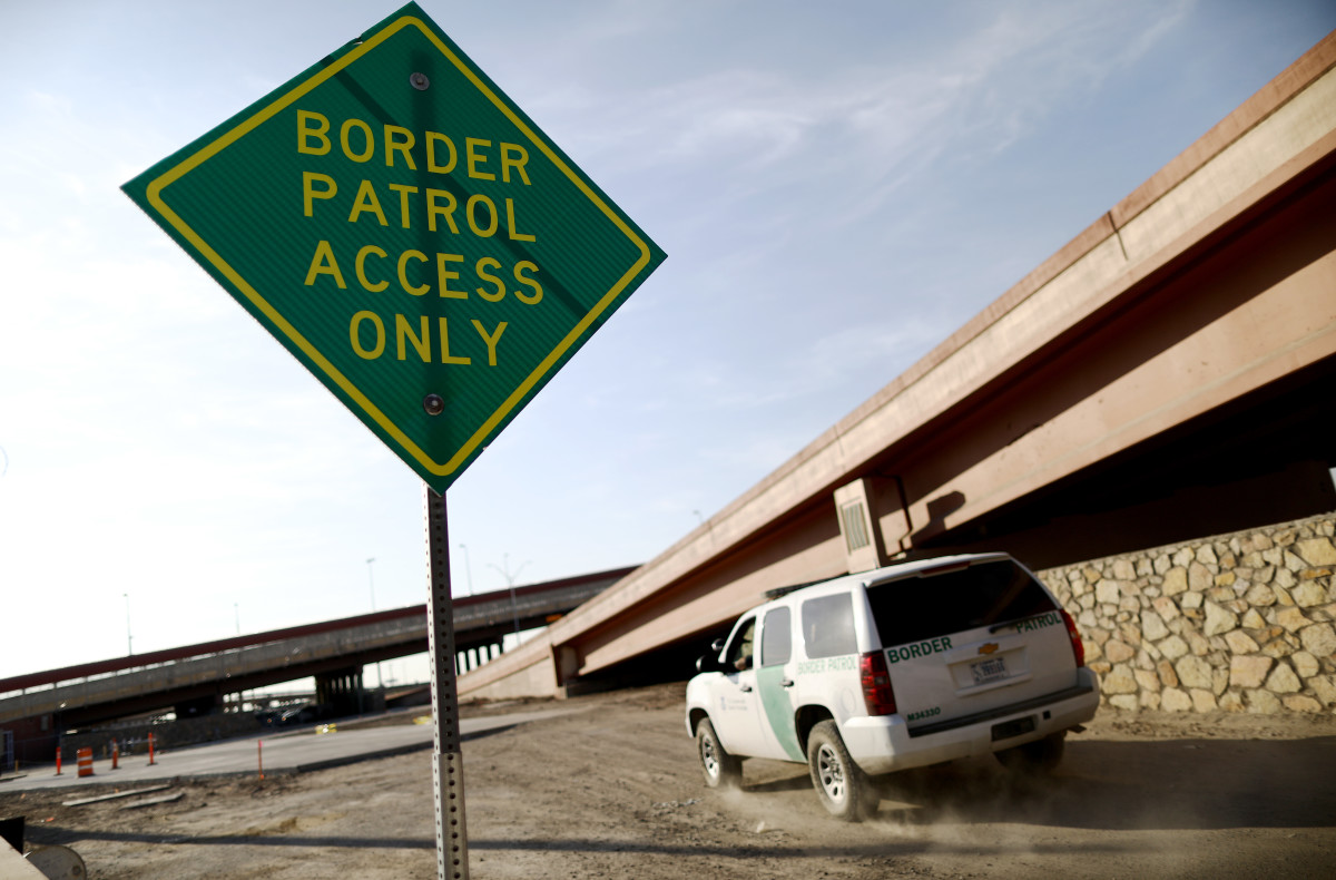 A U.S. Border Patrol vehicle passes a Border Patrol Access Only sign near the U.S.–Mexico border.