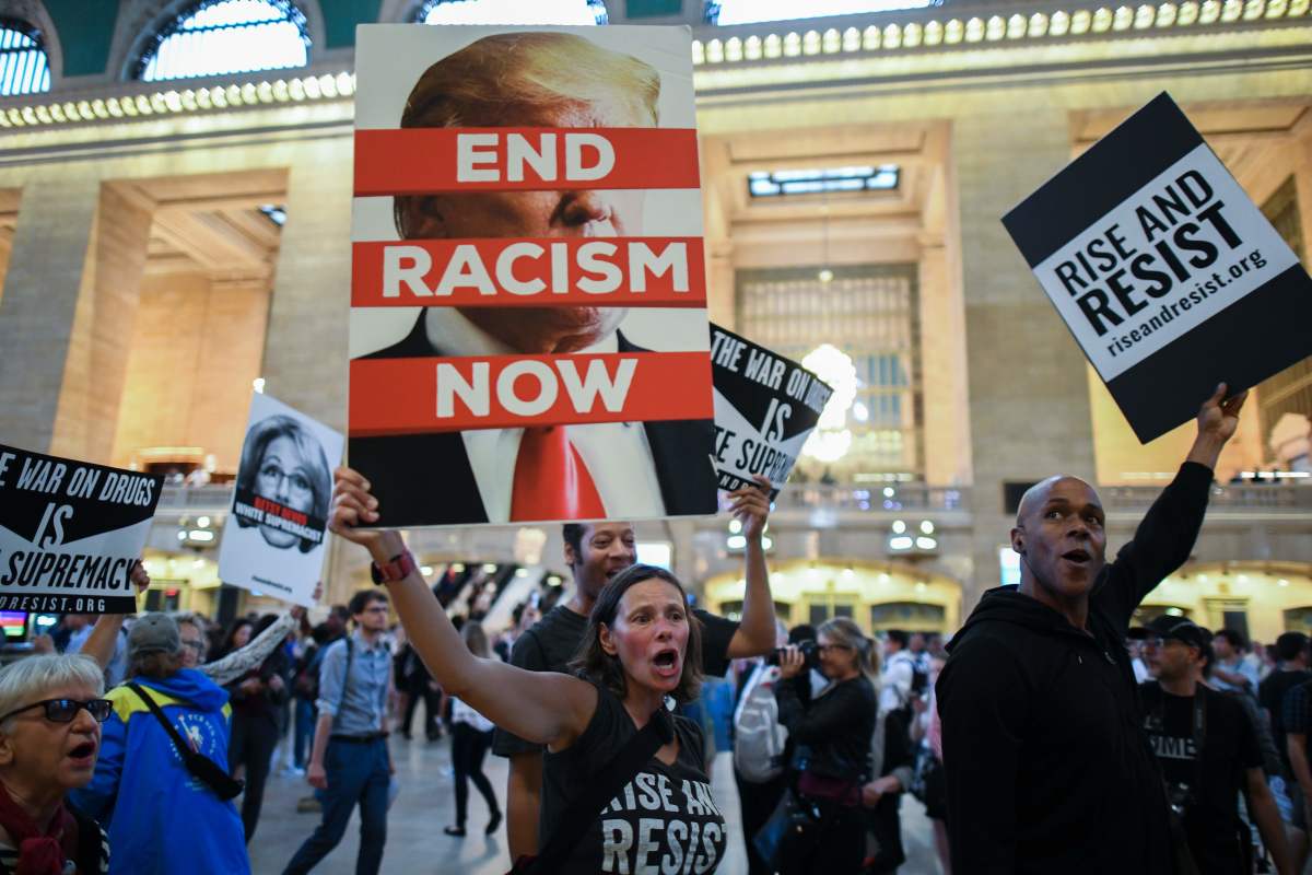 Protesters wave placards against President Donald Trump during a Rise and Resist Against White Supremacy demonstration inside the Grand Central Station in New York on September 18th, 2017.