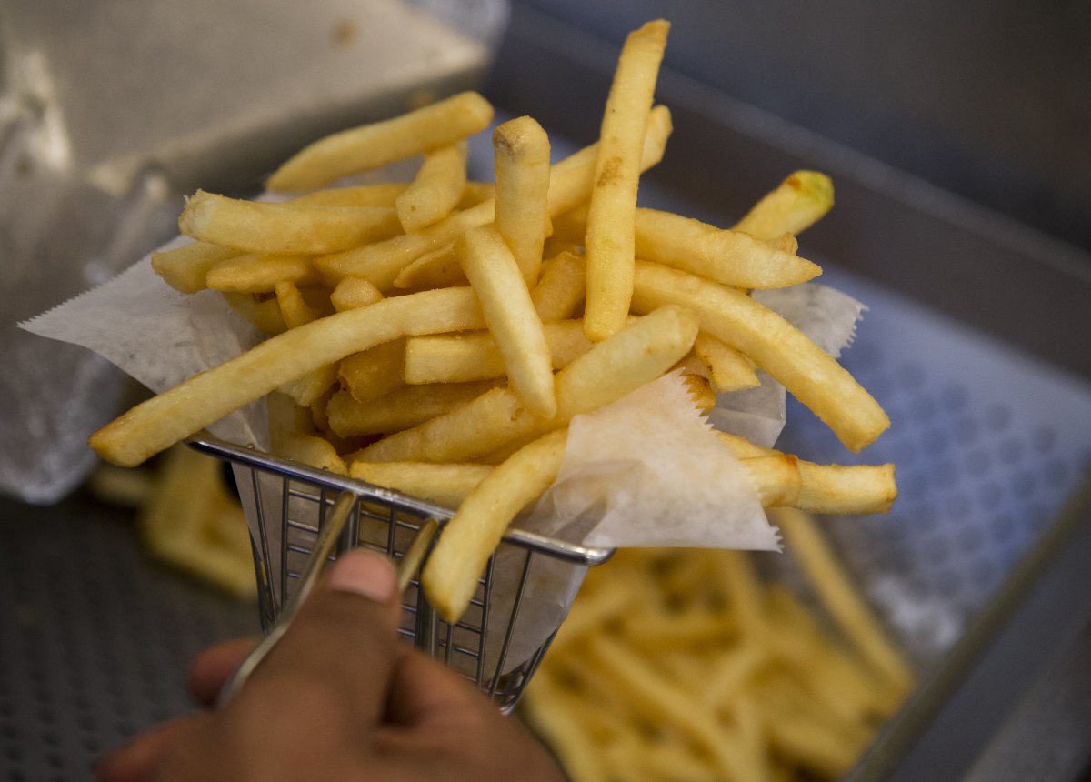 A cook prepares french fries from a fryer in the kitchen at Bolt Burgers in Washington, D.C.