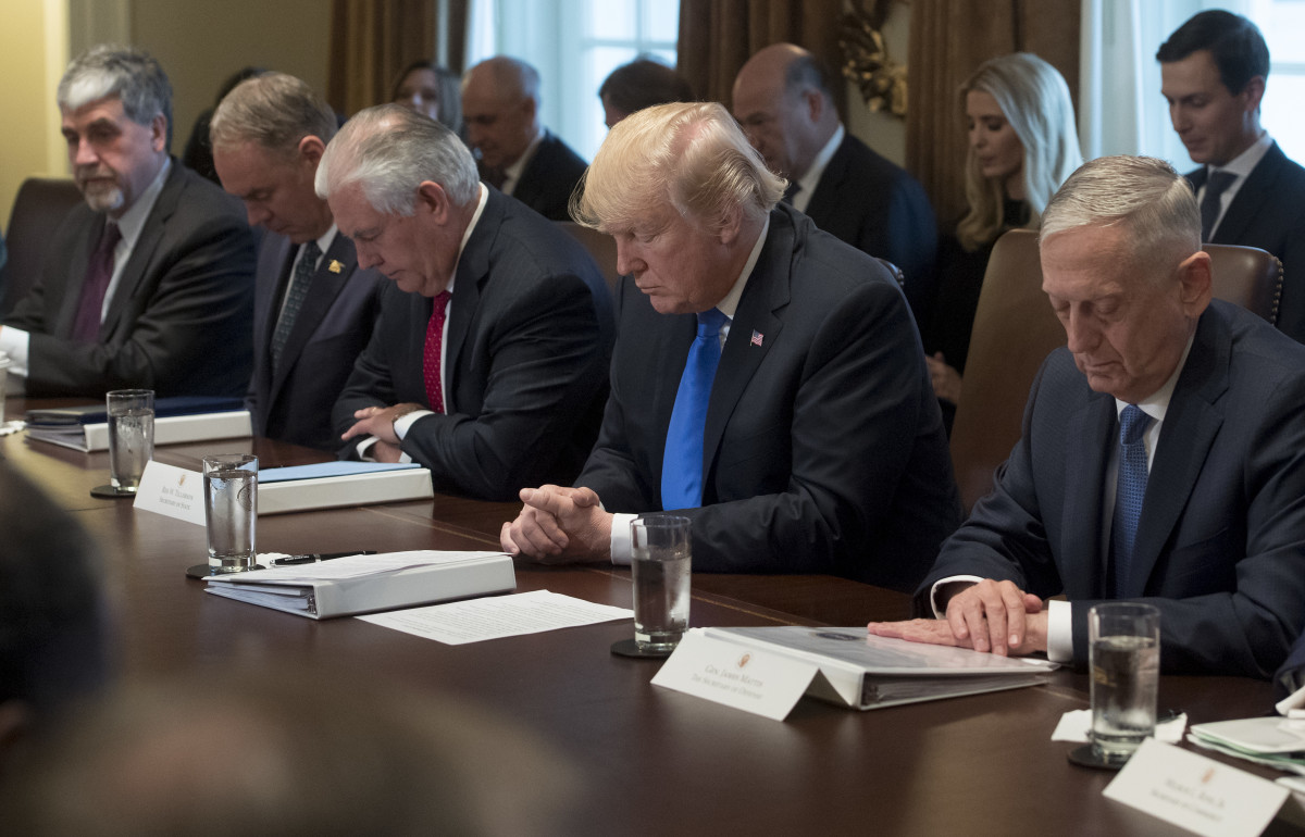 President Donald Trump bows his head during a prayer at a cabinet meeting in the White House in Washington, D.C., on December 20th, 2017.