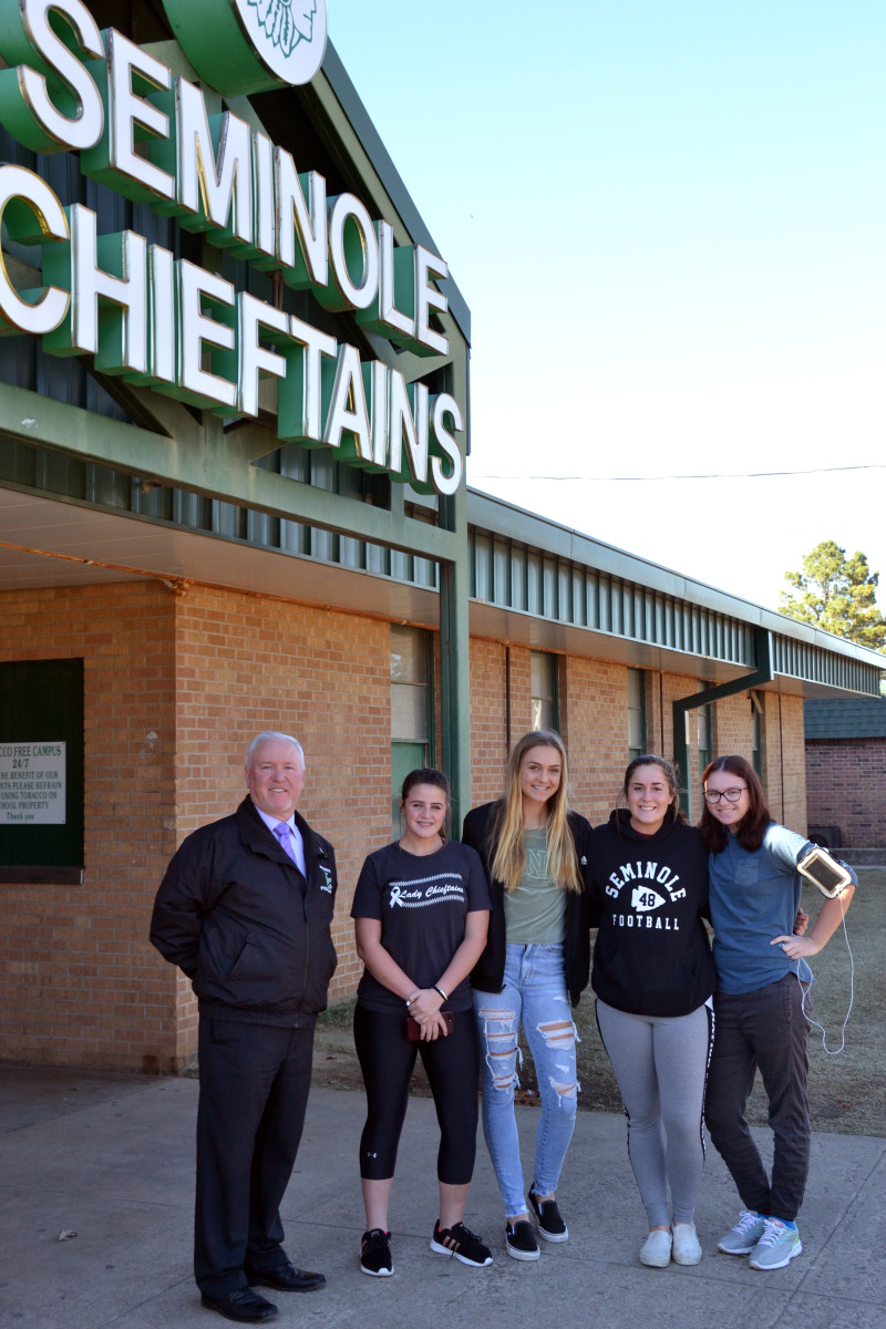 Superintendent Alfred Gaches stands with Seminole High School students outside a school gymnasium. Gaches recommended that the Oklahoma state board of education reject an application for a rural charter in Seminole, but the board disagreed.