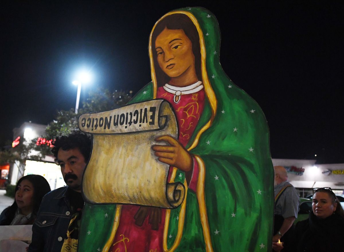 Residents facing eviction from their homes stage a protest led by a statue of the Virgin de Guadalupe holding an eviction scroll.