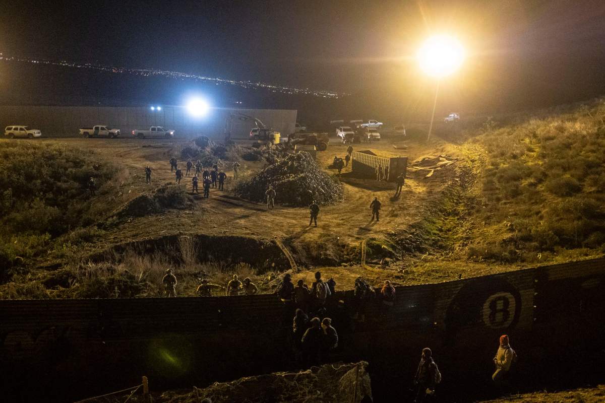 US border patrol officers deploy near the US-Mexico border fence to deter Central American migrants from crossing from Tijuana to San Diego, as seen from Tijuana, Baja California state, Mexico on January 1, 2019. - Around 100 Central American migrants made a failed attempt on New Year's Eve to cross over from Mexico into the United States. As night fell and people on both sides of the frontier prepared to celebrate New Year's Eve, the migrants tried to cross over but at least two smoke bombs were hurled and they ultimately held back.