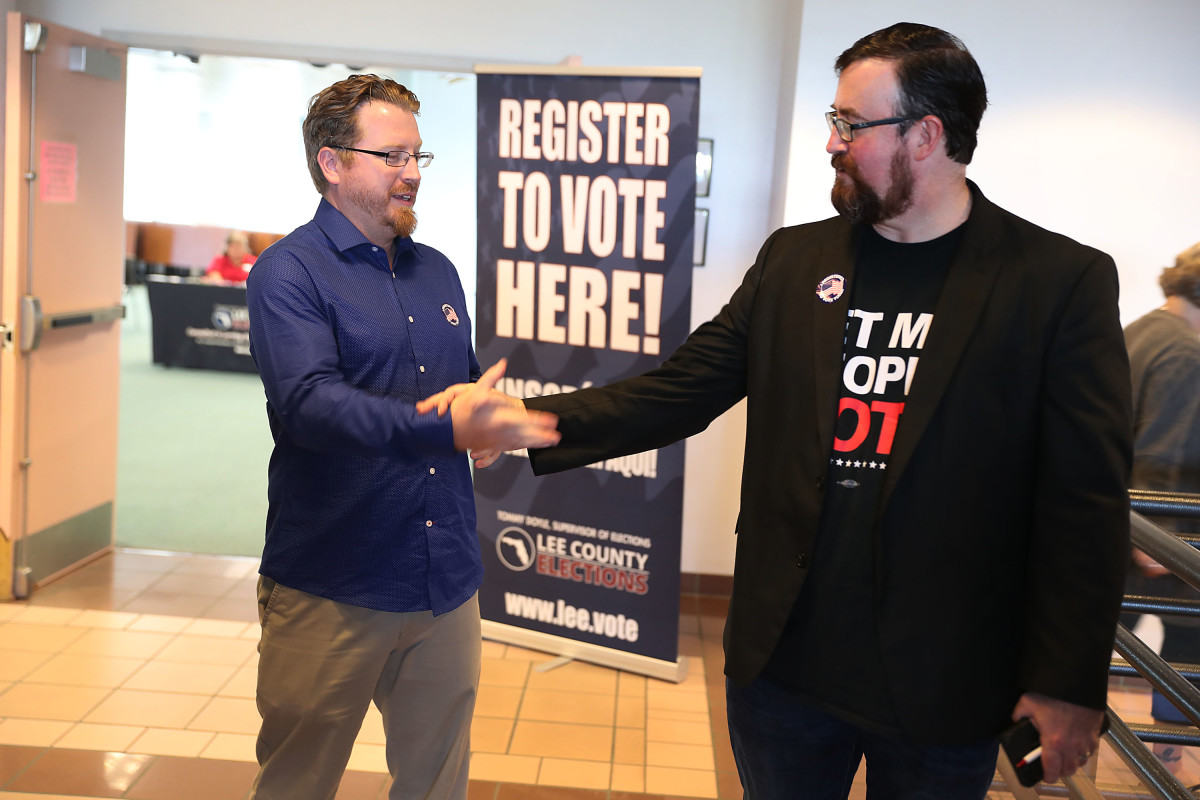 Lance Wissinger (left) and Neil Volz shake hands after turning in their voter registration forms at the Lee County Supervisor of Elections office on January 8th, 2019, in Fort Myers, Florida. Wissinger and Volz, both with felony records, became able to vote for the first time after a new constitutional amendment took effect.