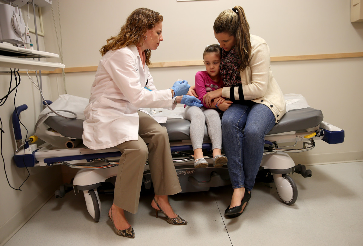 Miami Children's Hospital pediatrician Dr. Amanda Porro prepares to administer a measles vaccination to Sophie Barquin, age four, as her mother Gabrielle Barquin holds her during a visit to the Miami Children's Hospital on January 28th, 2015, in Miami, Florida.