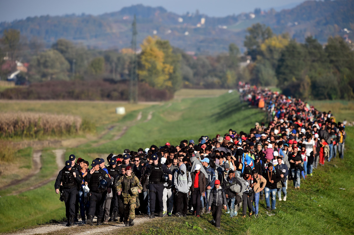 Migrants are escorted through fields by police and the army as they are walked from the village of Rigonce to Brezice refugee camp on October 24th, 2015, in Rigonce, Slovenia.
