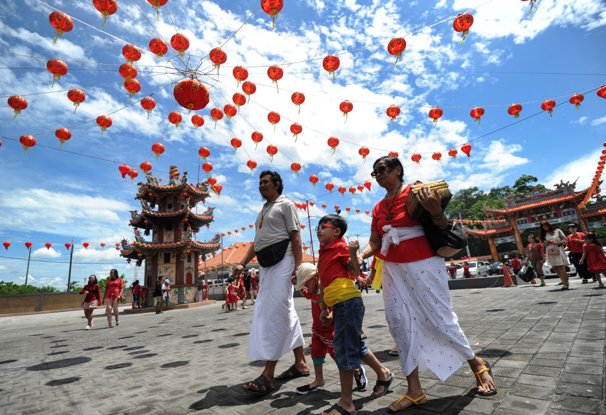 Balinese people wearing traditional outfits arrive at a Chinese temple to pray on the first day of the Lunar New Year in Denpasar on Indonesia's Bali island, on February 5th, 2019.