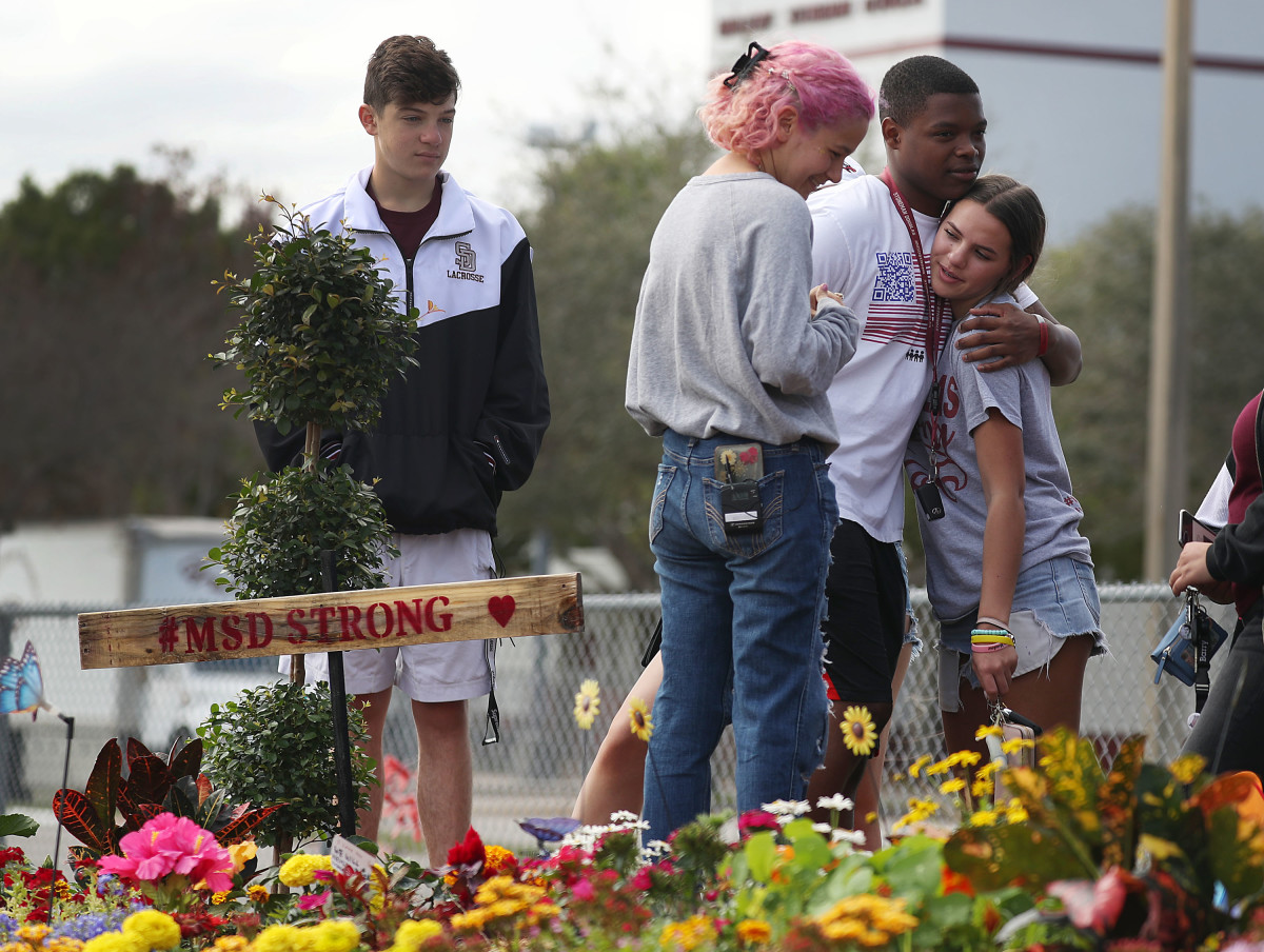 Students from Marjory Stoneman Douglas High School spend time together at a memorial set up outside the school on February 14th, 2019, in Parkland, Florida. A year ago on February 14th, 14 students and three staff members were killed during a mass shooting. For the one-year anniversary of the shooting, Pacific Standard took a look at federal, local, and non-governmental gun-violence proposals.