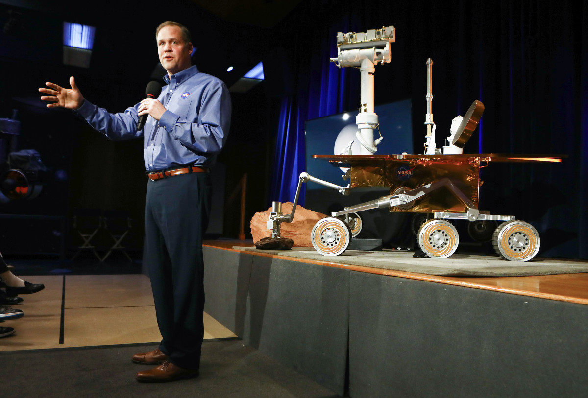 NASA Administrator Jim Bridenstine in front of a model of the Opportunity rover