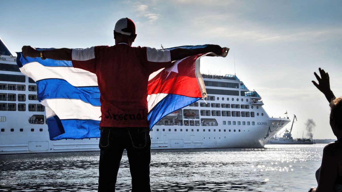 A man waves a Cuban flag at the Malecon waterfront as the first U.S.-to-Cuba cruise ship to arrive in the island nation in decades glides into the port of Havana, on May 2nd, 2016.