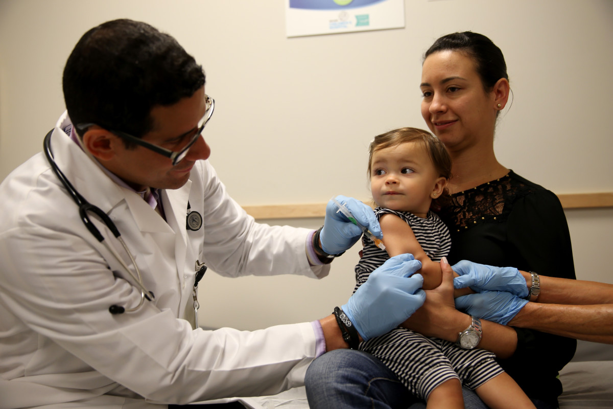 Daniela Chavarriaga holds her daughter, Emma Chavarriaga, as pediatrician Jose Rosa-Olivares, M.D., administers a measles vaccination during a visit to the Miami Children's Hospital on June 2nd, 2014, in Miami, Florida.