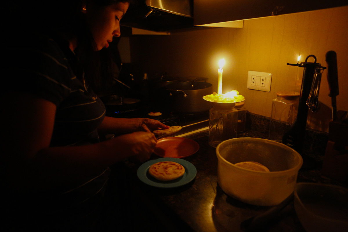 On March 12th, 2019, a woman cooks dinner at her house during a blackout, which affects the water pumps, in Caracas, Venezuela. Over 70 percent of the country was in darkness amid an ongoing political dispute between President Nicolas Maduro and Juan Guaido, who has been declared interim president by the national assembly.