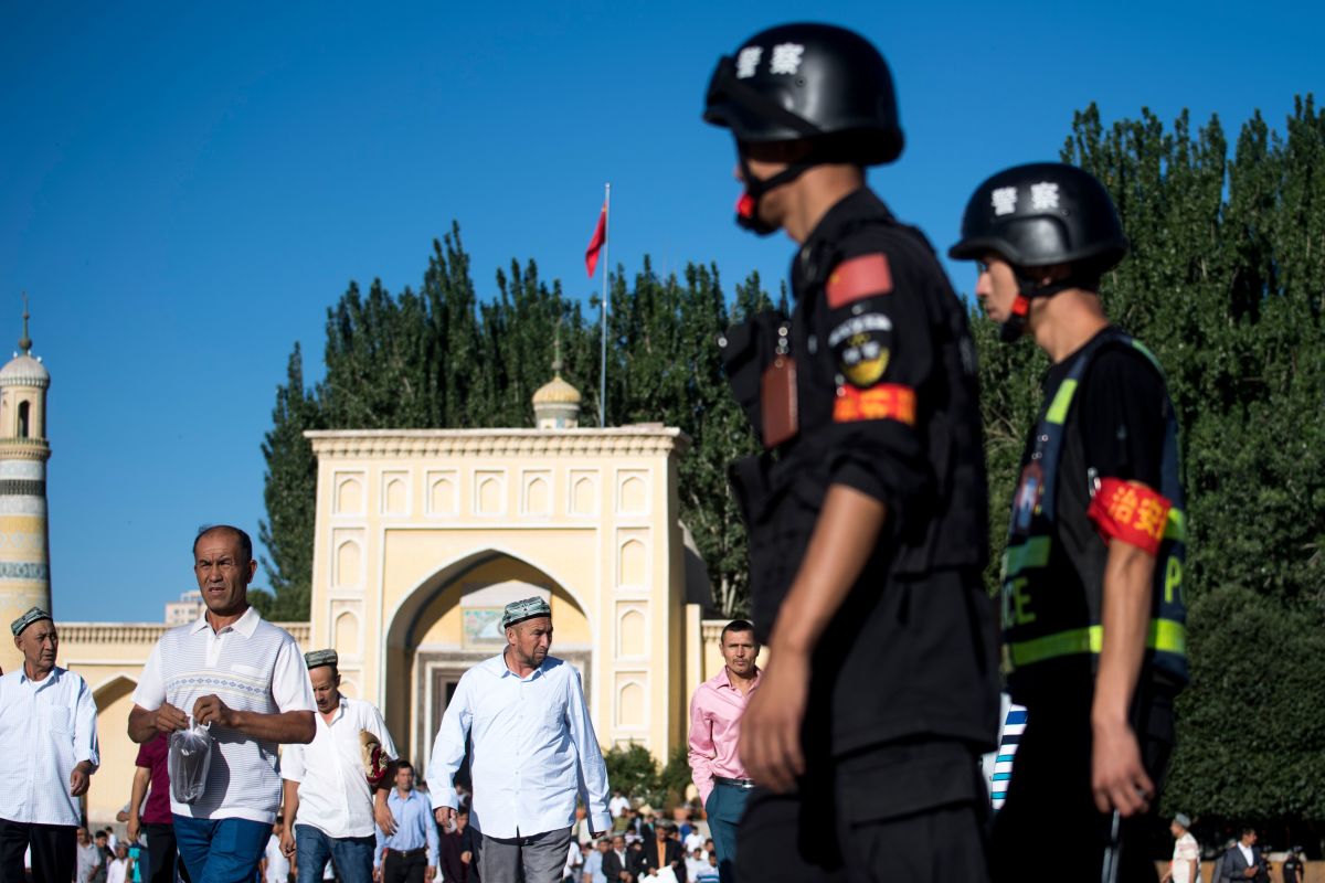 Police patrol as Muslims leave the Id Kah Mosque after morning prayer on Eid al-Fitr in the old town of Kashgar in China's Xinjiang Uyghur Autonomous Region on June 26th, 2017. The increasingly strict curbs imposed on the mostly Muslim Uyghur population have stifled life in the tense Xinjiang region, where beards are partially banned and no one is allowed to pray in public.
