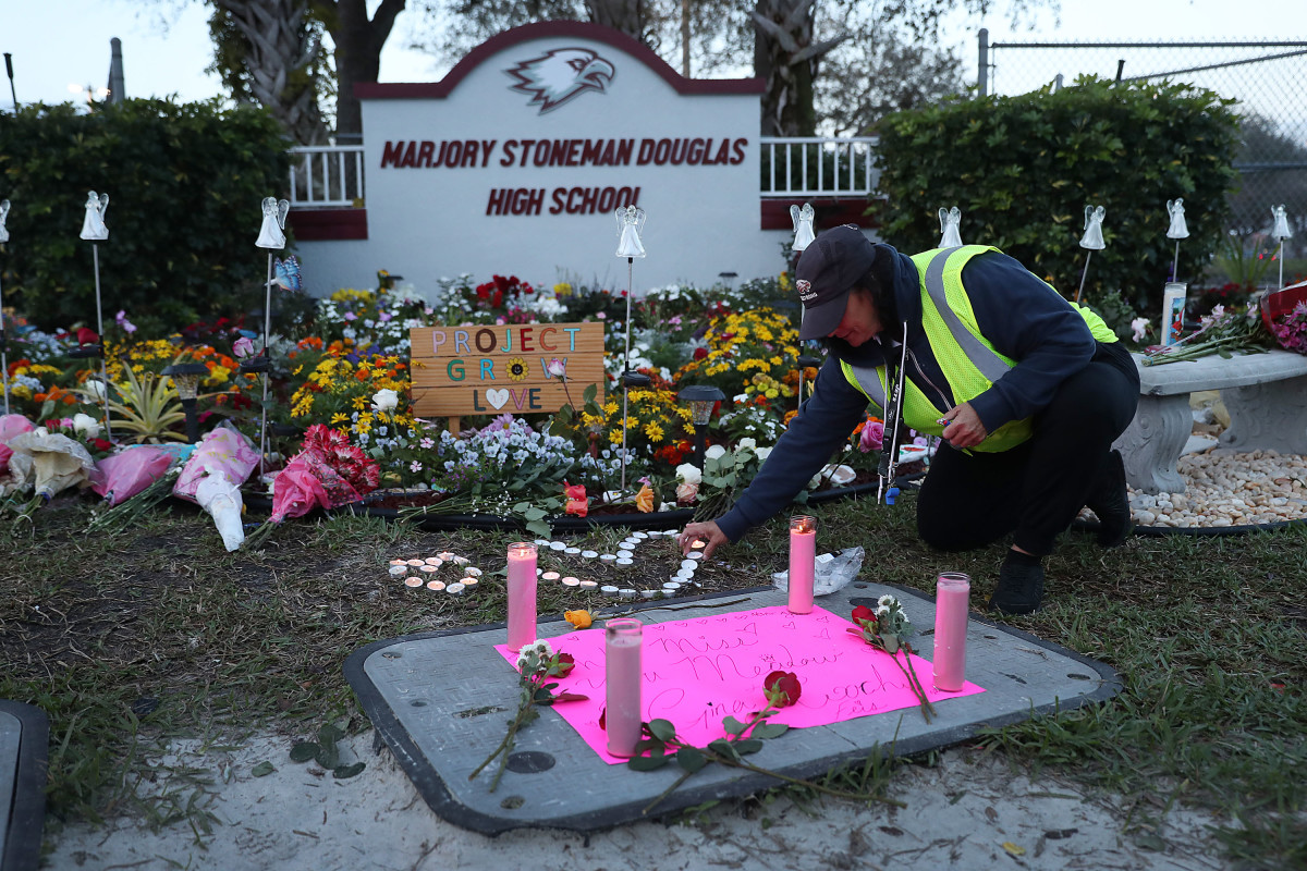 Wendy Behrend, a school crossing guard who was on duty when a shooter opened fire in Marjory Stoneman Douglas High School in Parkland, Florida, pays her respects at a memorial one year after the shooting.