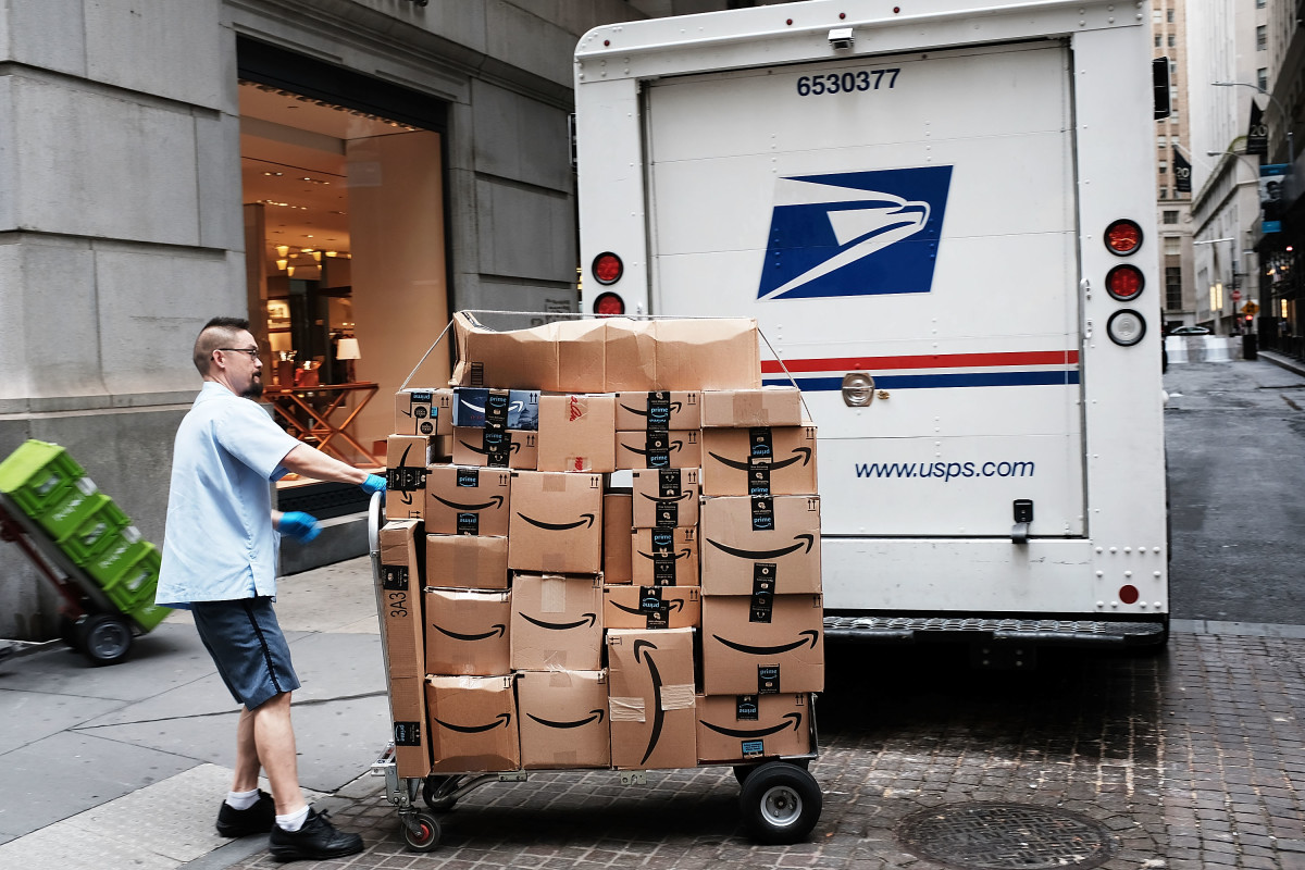 A US Postal worker delivers Amazon boxes outside of the New York Stock Exchange on October 11th, 2018 in New York City.