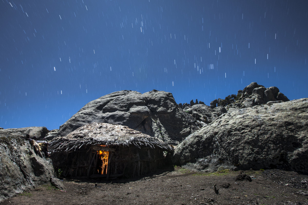A cook fire glows inside a hut on the Ethiopian Highlands.