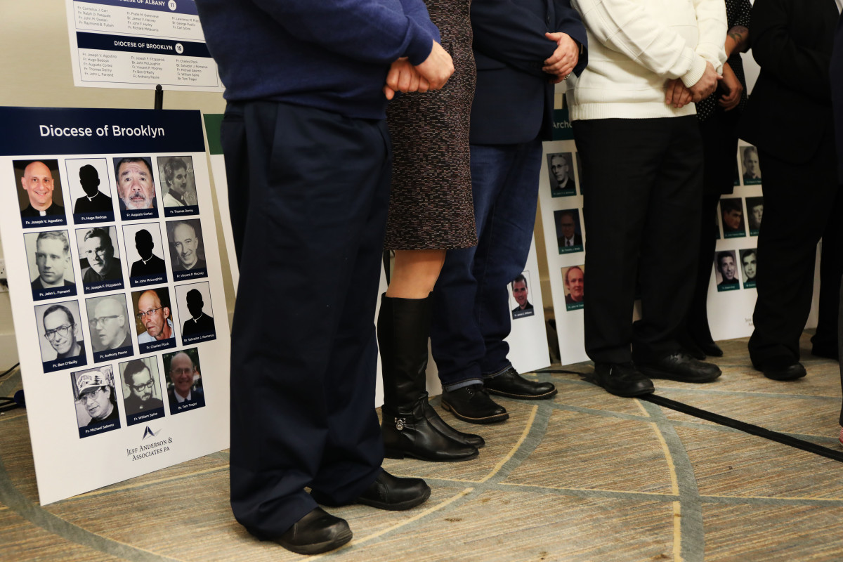 Survivors of sexual abuse by priests and clergy stand before photos of accused religious men during a news conference with lawyer Jeff Anderson of Jeff Anderson & Associates on February 14th, 2019, in New York City.