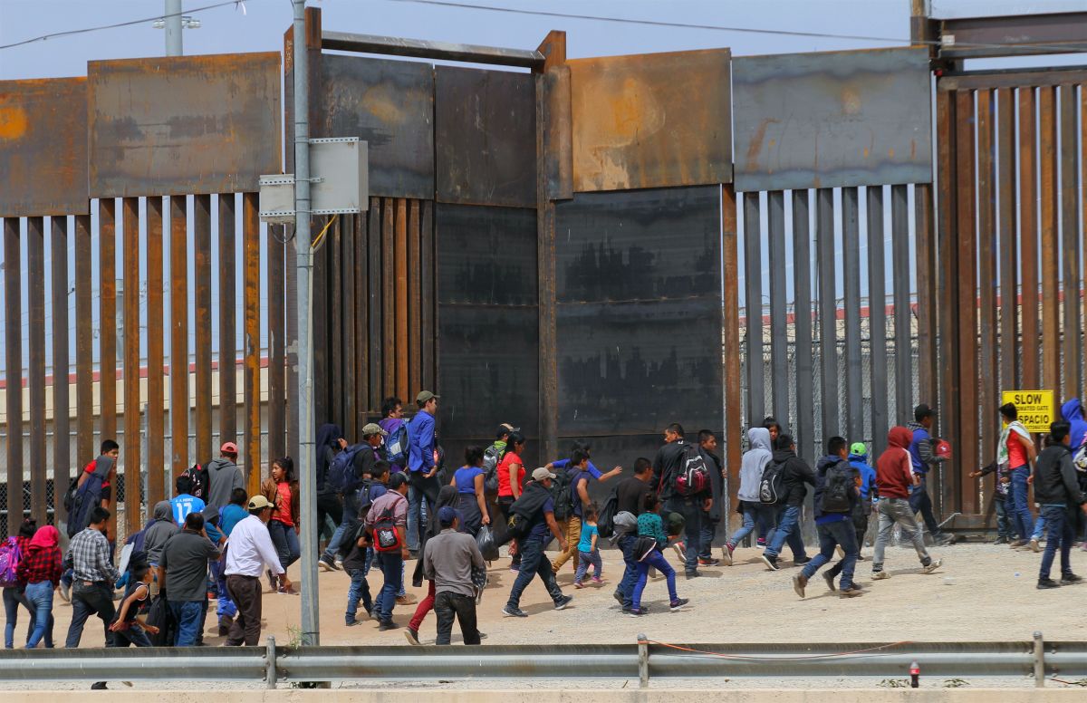 Central American migrants walk as they are detained by U.S. Customs and Border Patrol agents at the border wall in Ciudad Juarez, Chihuahua state, Mexico, on May 7th, 2019.