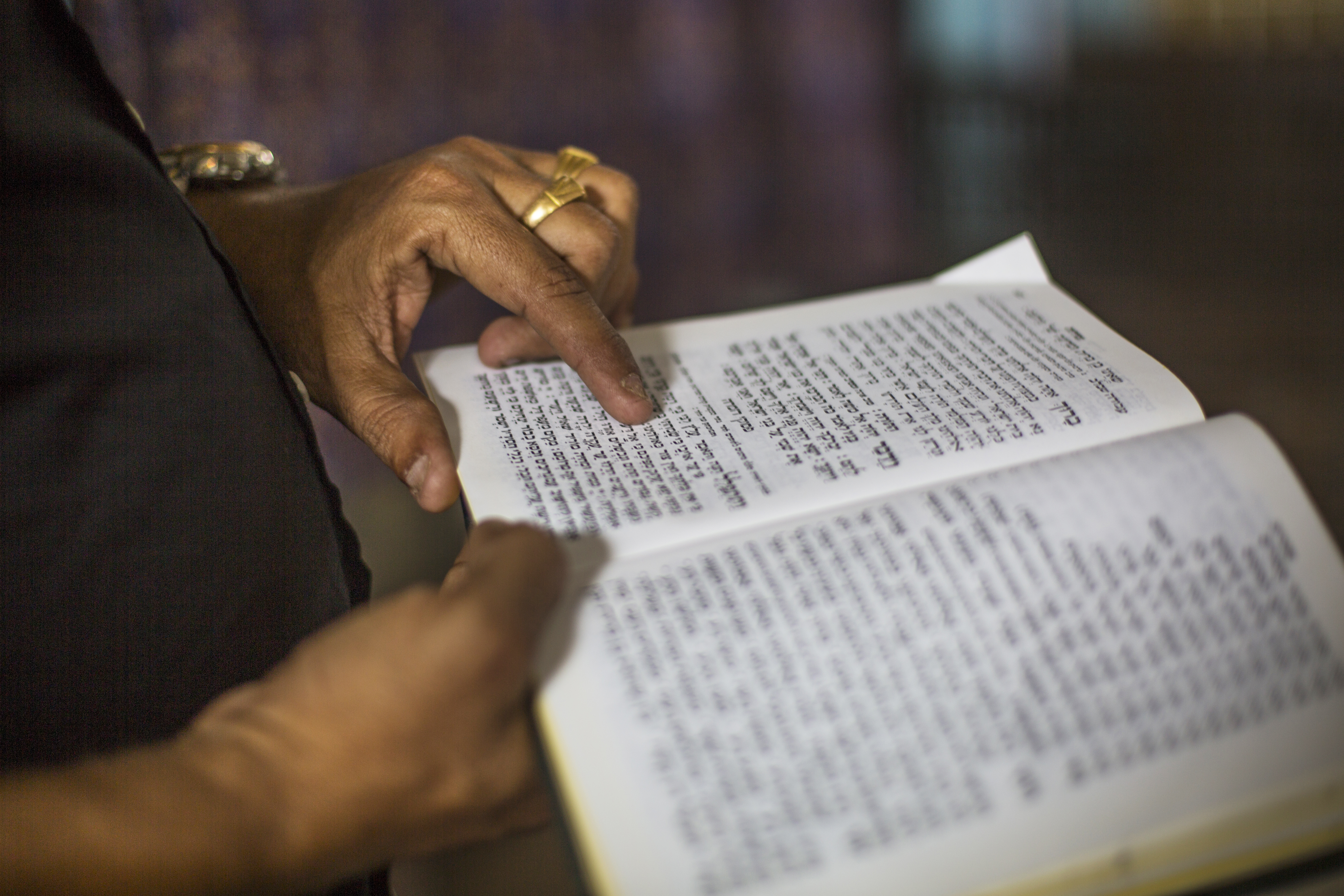 Babu opens his prayer book and starts singing the prayer he said his grandmother made him sing before breakfast every morning. 